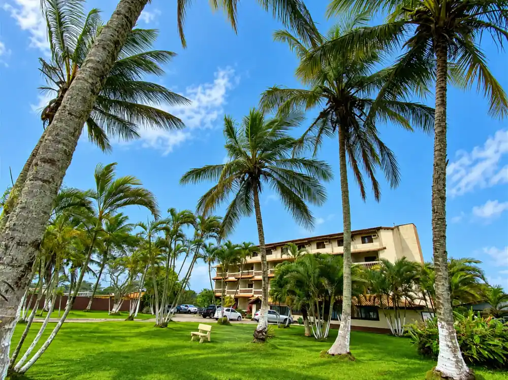 Jardins com palmeiras ao redor do Leviv Praia Hotel